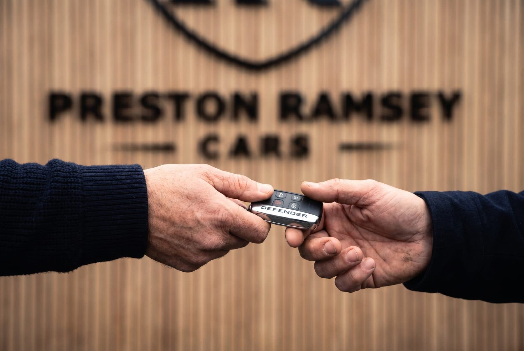 Keys being handed over in front of the Preston Ramsey Cars sign